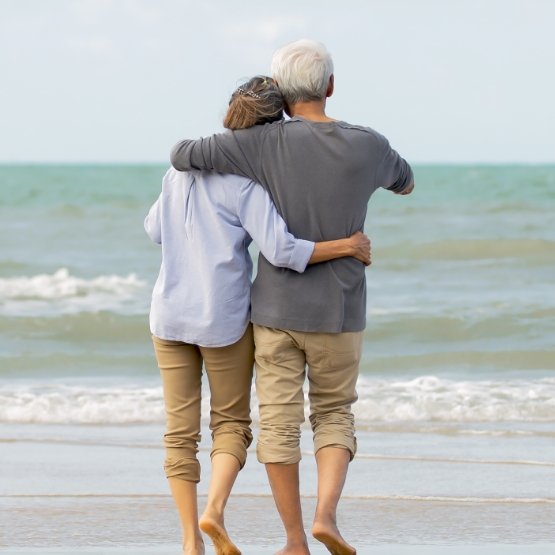 Back of couple at a beach hugging